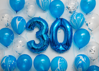 Blue number 30 celebration foil balloons with helium balloons on white background. Party decoration...