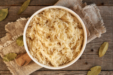 A bowl of fermented cabbage or sauerkraut on a table, top view