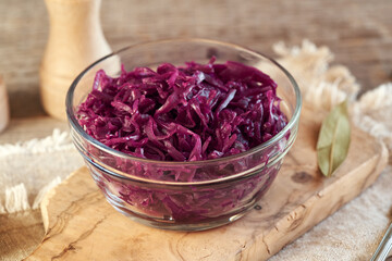 Purple fermented cabbage or sauerkraut in a transparent glass bowl