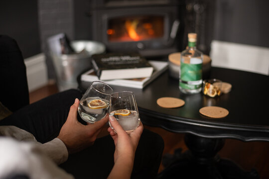 anonymous couple drinking gin in front of a fire