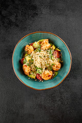 Top-down view of a vibrant shrimp and quinoa salad with avocado and tomatoes in a turquoise bowl
