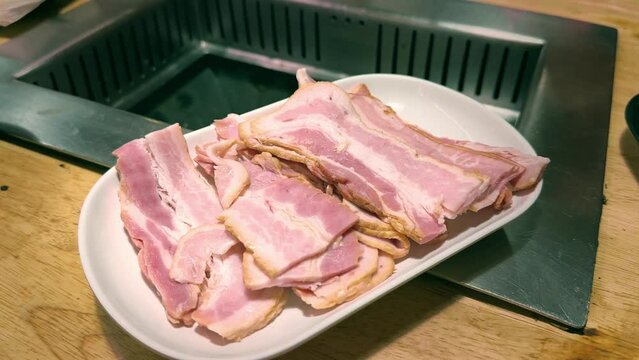 Freshly prepared raw pork and lamb chops on a cutting board, ready for cooking, showcasing a variety of meat options