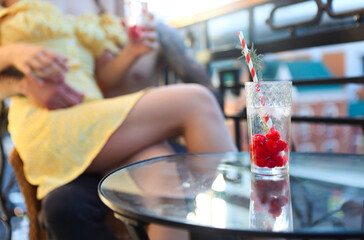 Couple in love drinking summer refreshing lemonade with rasberry on a balcony