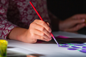 Close up young child learning to painting with paints.  Children development concept.