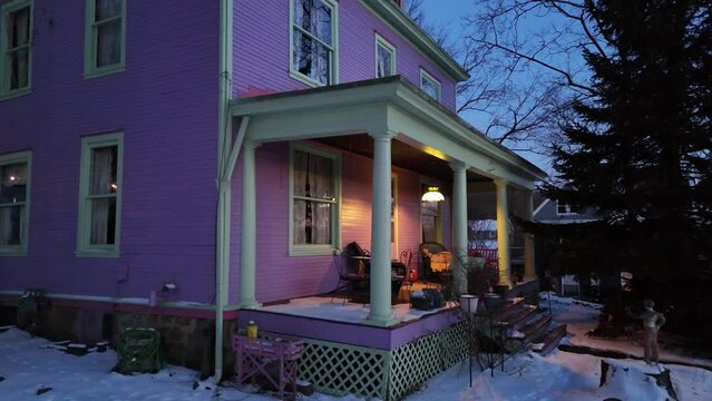 An evening slow close dolly approach to a violet home sitting on a hillside in the cold winter. Pittsburgh suburbs.  	