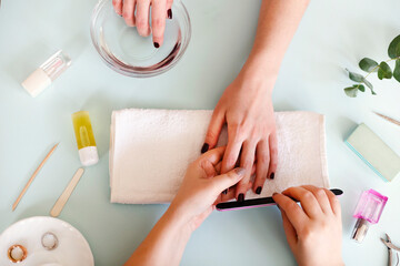 Woman getting manicure procedure in salon - obrazy, fototapety, plakaty