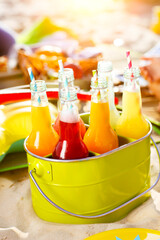 Bottles of lemonade standing in green bucket