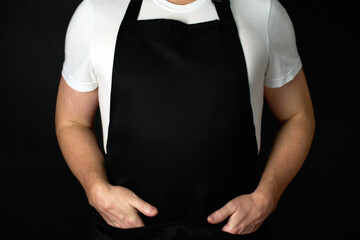 Chef wearing apron, standing with hands on pockets