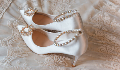 Weddings women white shoes with a heels with a flowers and pearls. Concept of Wedding, accessorize