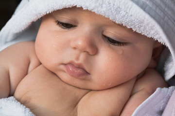 Beautiful caucasian newborn baby after washing in bath. Close-up portrait 
