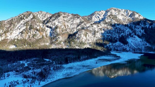 Drohnenflug &uuml;ber dem See in den Bergen in sch&ouml;ner Landschaft im Winter im Salzkammergut