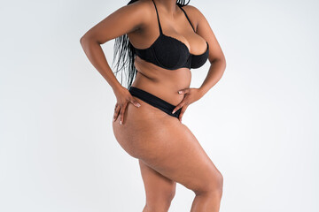 Curvy busty plus size model in push up bra on gray background, overweight African black woman in sexy lingerie, fat body - obrazy, fototapety, plakaty