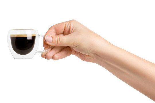 A woman's hand holds a transparent cup with double glass and coffee on a blank background.