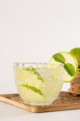 Caipirinha glass of Pinga Cocktail with Lemon on a Smooth white Background in front view photo