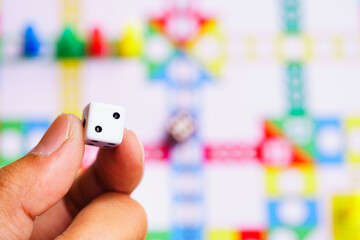 Close up hand hold the dice on board game using for education and business strategy concept