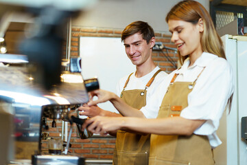 Professional Asian female barista pouring a hot milk over the espresso in coffee cup. 