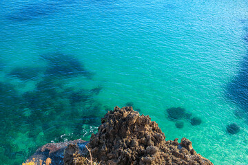 Rock on emerald sea in Apulia, Italy.