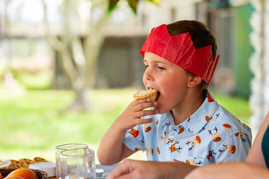 boy eating fruit mince pie while family is distracted serving up dessert