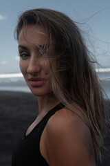 Portrait of a sporty girl on a black beach