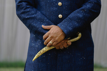 Royal dagger in the beautiful hands of the groom