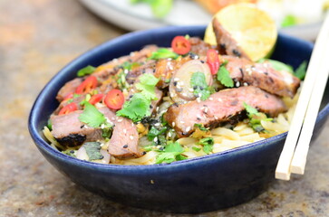 close up view of asian salad nam tok with noodles and beef