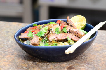 close up view of asian salad nam tok with noodles and beef	