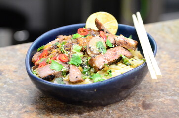 close up view of asian salad nam tok with noodles and beef
