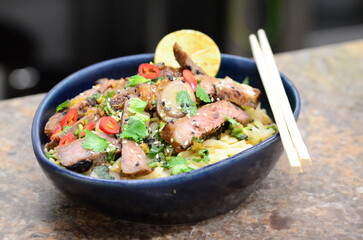 close up view of asian salad nam tok with noodles and beef