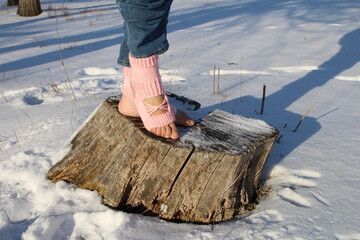 A child standing on a log in the snow