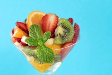 Fruit cocktail in martini glass on bright background. Minimal food vegan concept.