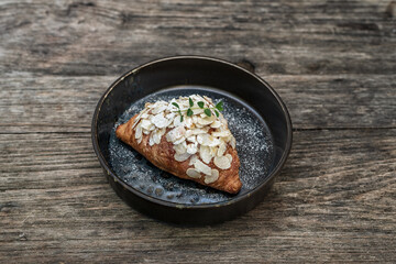Close-up of croissant in plate on wooden table.