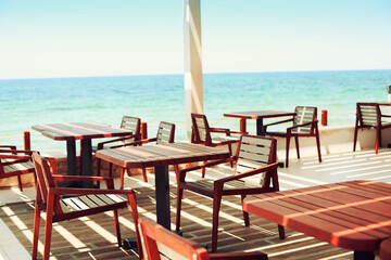 Tables and chairs at outdoor restaurant on the beach