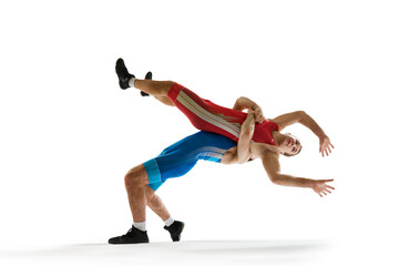 Fototapeta na wymiar One wrestler in red uniform thrown by opponent in blue, both captured mid-fall in motion against white studio background. Concept of sport, mixed martial arts, active lifestyle, movement.
