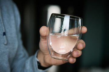 Man drinks water, Close-up shot of man holding glass of fresh water, Quenching thirst, Lifestyle...