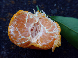 peeled tangerine on a black background
