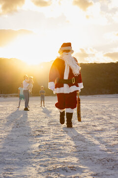 father christmas returns to the crease in a game of beach cricket at sunset
