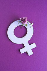 symbol of women's day cut out of paper with flowers on purple background.