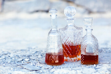 Three whiskey decanters against a light gray background