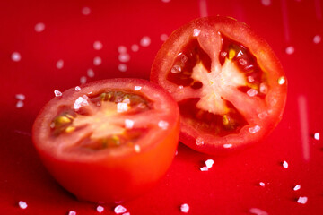 Tomatoes being sprinkled with salt. 