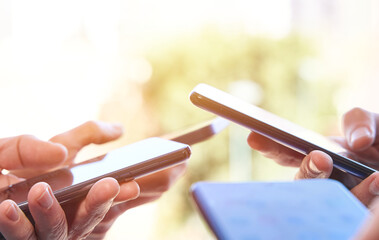 Digital technology and smartphone addiction. Four hands using smartphone on sunny day