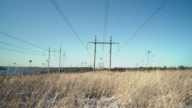  Electrical equipment, high voltage power line insulators on winter sky backdrop. Transmission tower. Intricate interplay of poles cables and transformers. World electricity crisis.