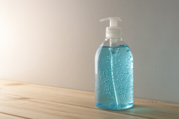 Hand sanitizer in a bottle on wooden table. Coronavirus prevention concept.