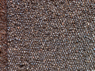 Stones textured fence gabion steel metal grate stone wall basket made of mesh and stones background stone and gravel enclosed in metal cage to create wall and facade. Steel mesh barrier gravel stone.