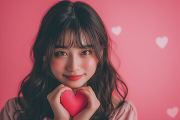 Smiling woman holding a red heart, radiating love and beauty on Valentine's Day with a sweet and happy expression, showcasing the essence of romance and happiness