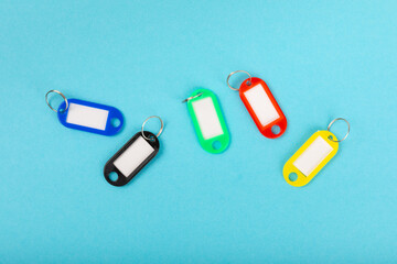 Plastic key ring in different colors with a place for a signature on a bright colored background. Bunch of keys with keychain. Mock-up keychain.Copy space.Concept for renting and selling real estate.