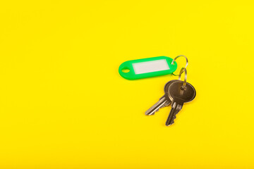 Plastic key ring in different colors with a place for a signature on a bright colored background. Bunch of keys with keychain. Mock-up keychain.Copy space.Concept for renting and selling real estate.