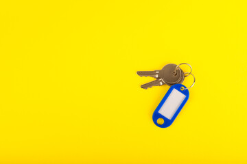 Plastic key ring in different colors with a place for a signature on a bright colored background. Bunch of keys with keychain. Mock-up keychain.Copy space.Concept for renting and selling real estate.