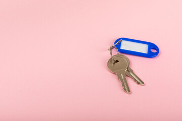 Plastic key ring in different colors with a place for a signature on a bright colored background. Bunch of keys with keychain. Mock-up keychain.Copy space.Concept for renting and selling real estate.