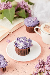  Aesthetic female lifestyle. Book and purple floral cake. Violet sweet no sugar dessert among lilac flowers