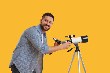 Happy astronomer with telescope on orange background